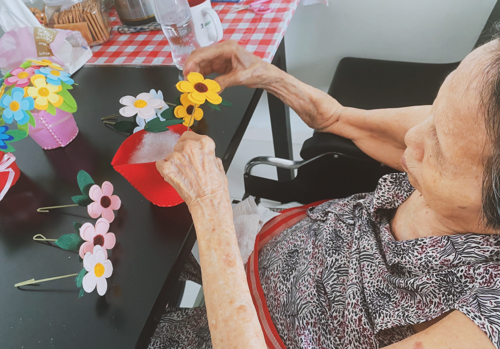 Mdm Lim creating a felt flower bouquet during a session with Homage