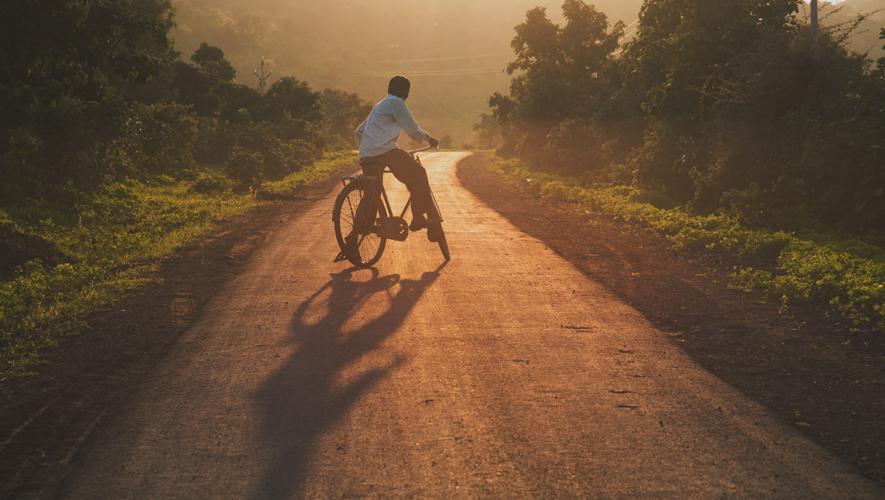 Young man cycling at the sunrise