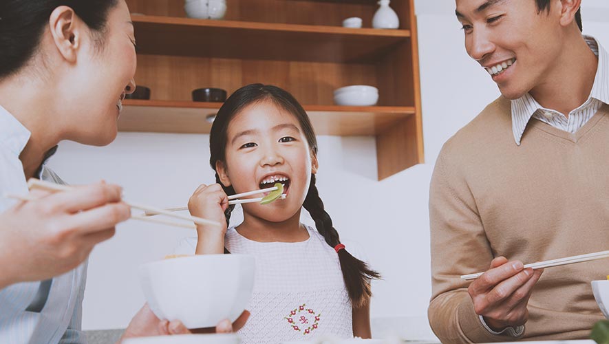 A family of three, enjoying a meal at home