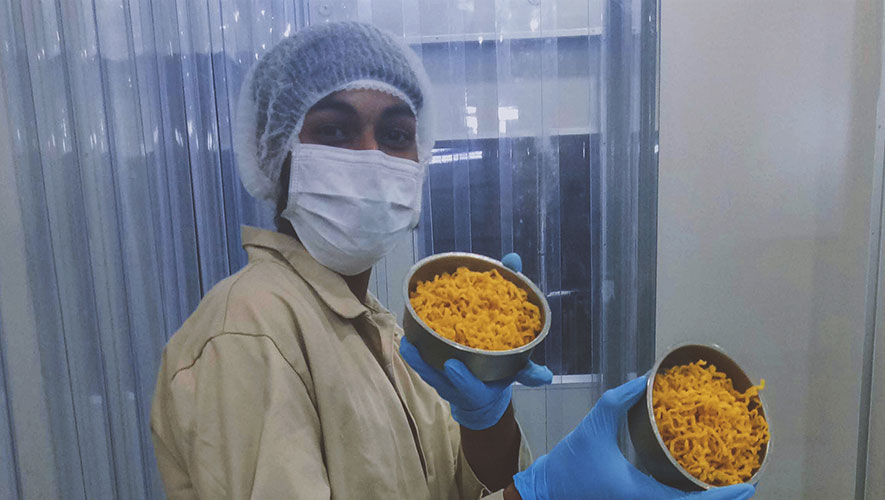 Woman in a food supply chain showcasing noodles produced in innovative methods