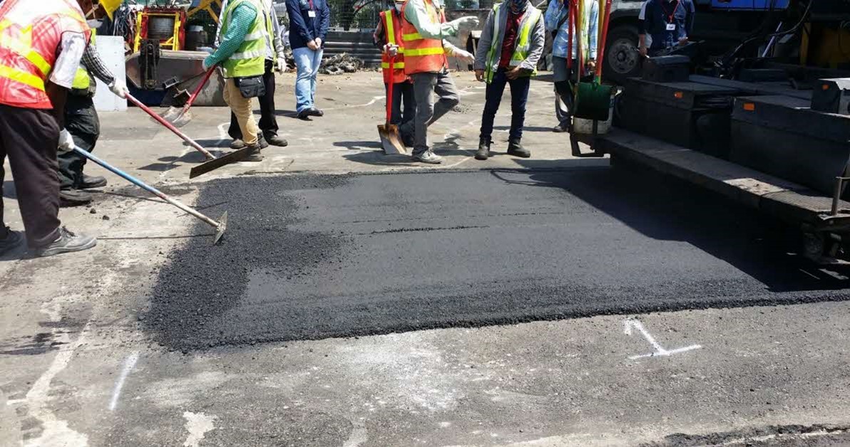 Paving NEWBitumen on a road surface for testing in Singapore